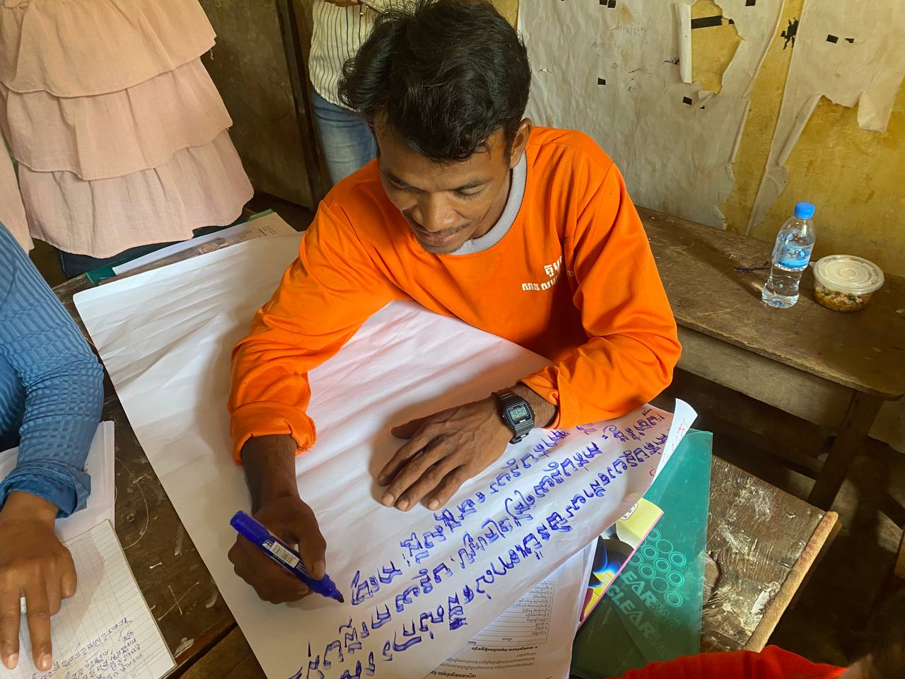 Young man writing in Khmer 