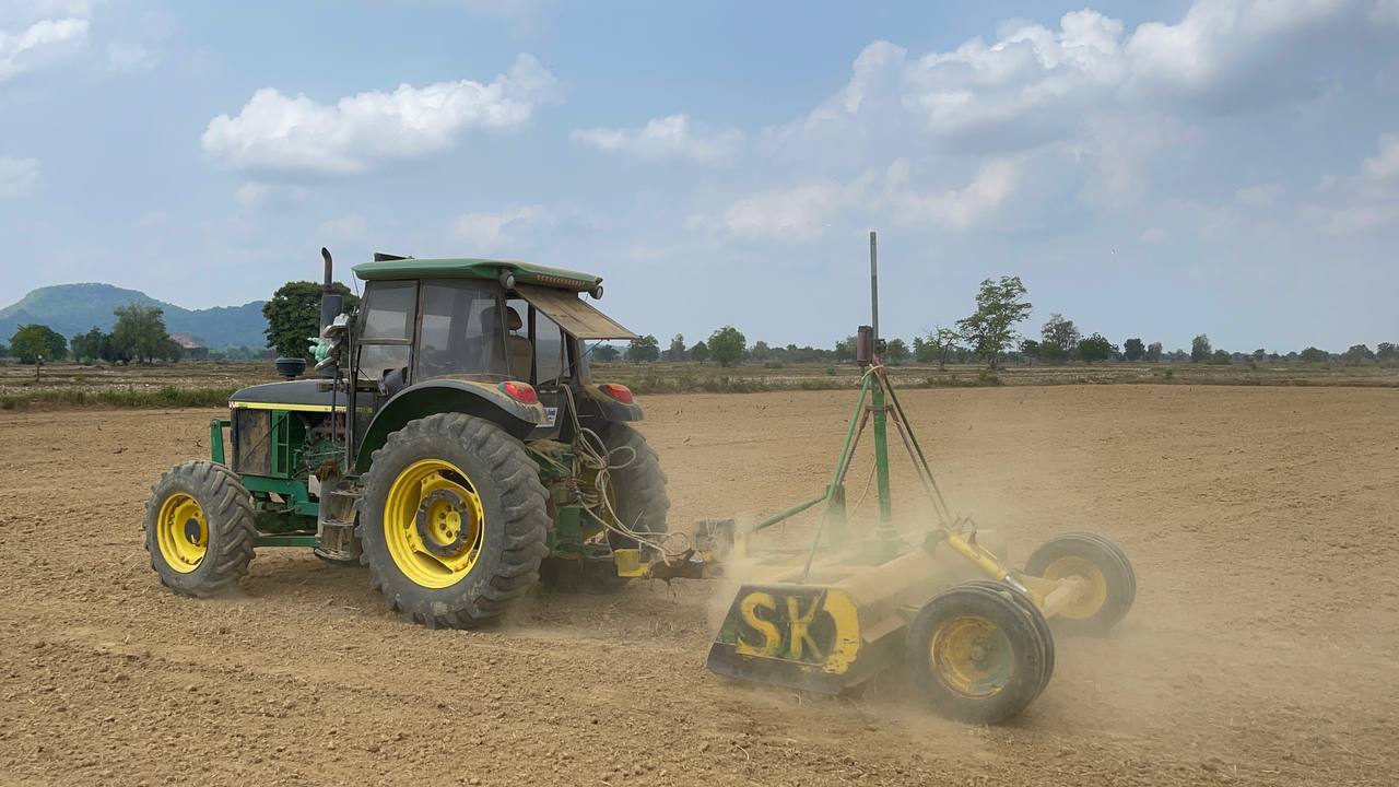 Tractor on a dry field levelling the ground