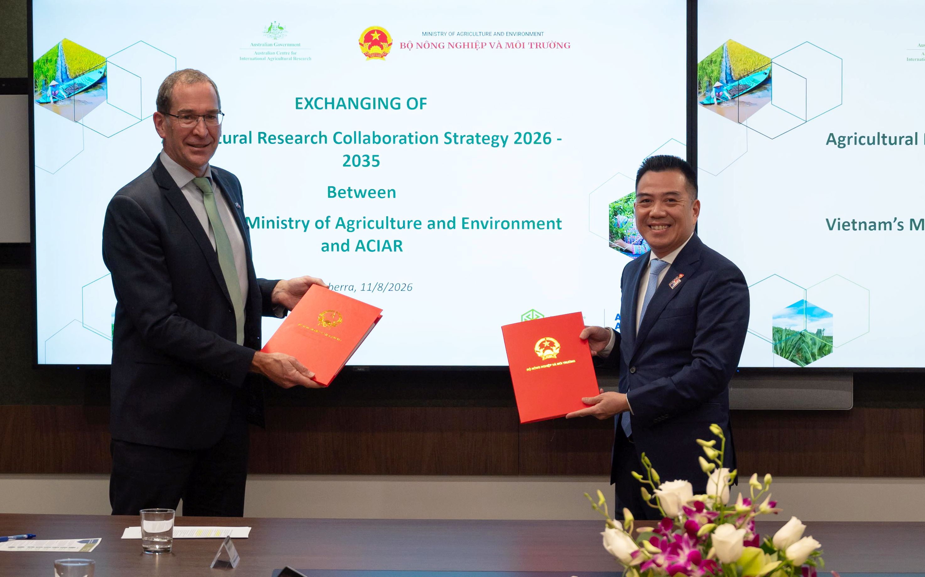 ACIAR and Vietnam Ministry of Agriculture and Environment representatives exchange signed research collaboration documents in Canberra.