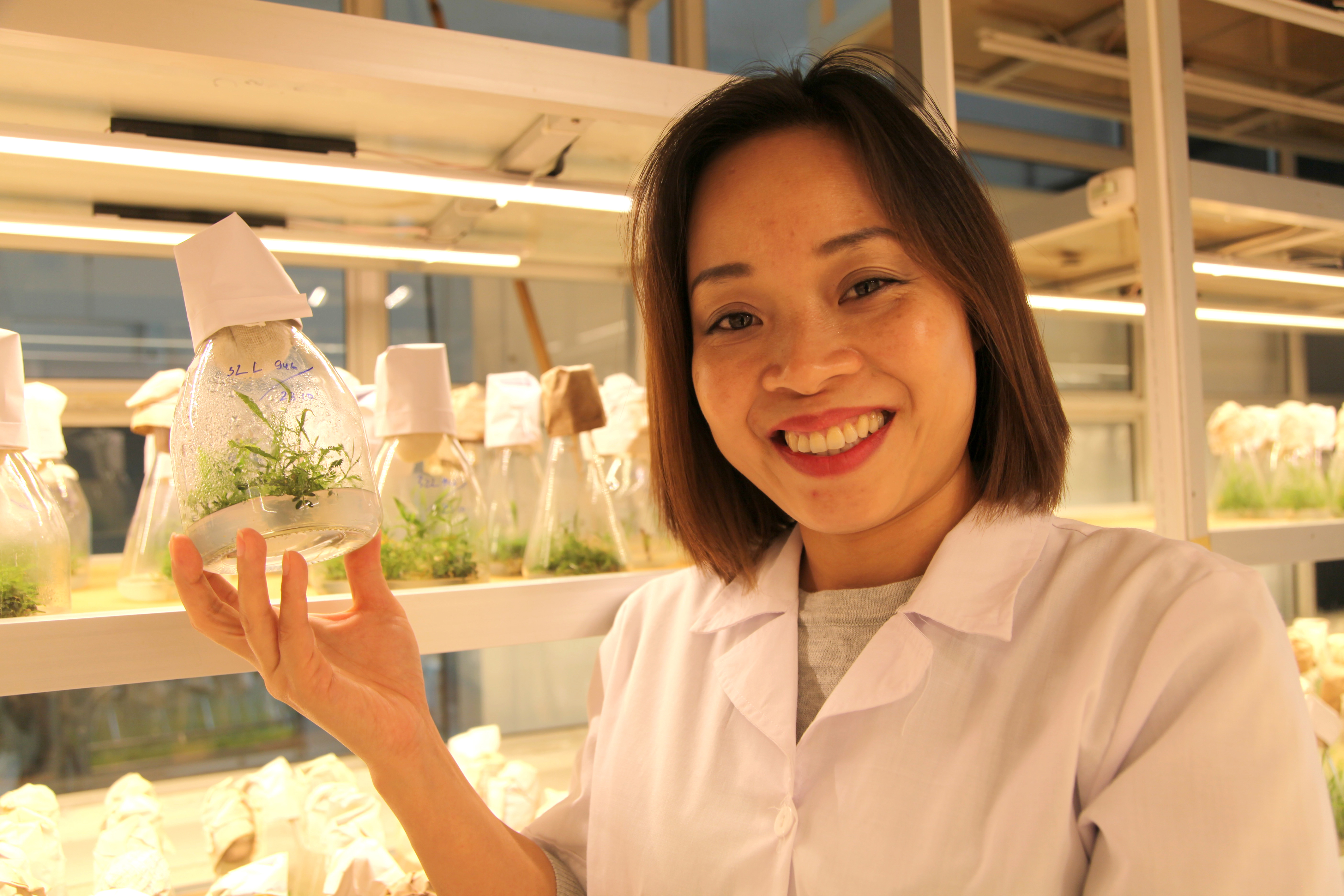 Lady in a lab holding a plant