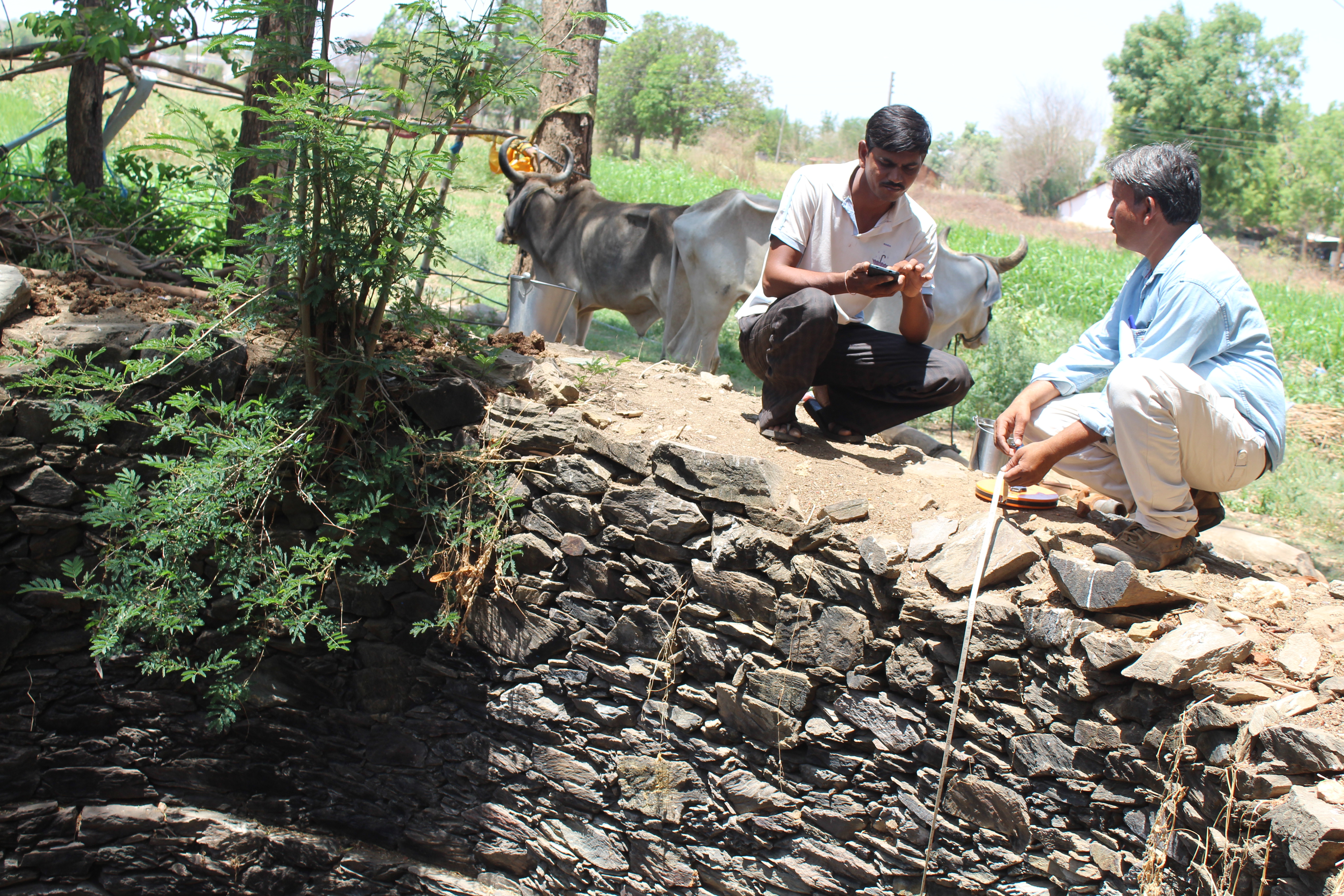 Men kneeling beside a well