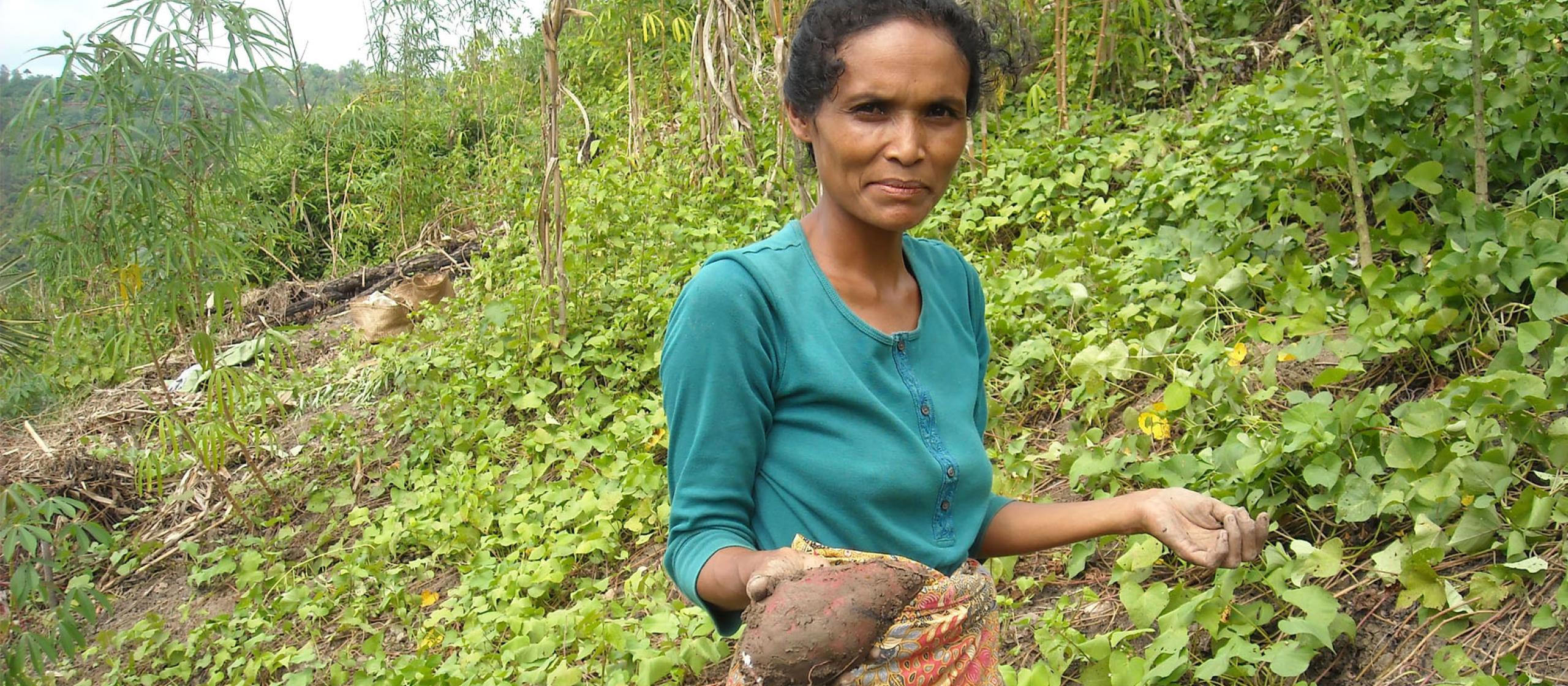 A farmer holds up her harvest