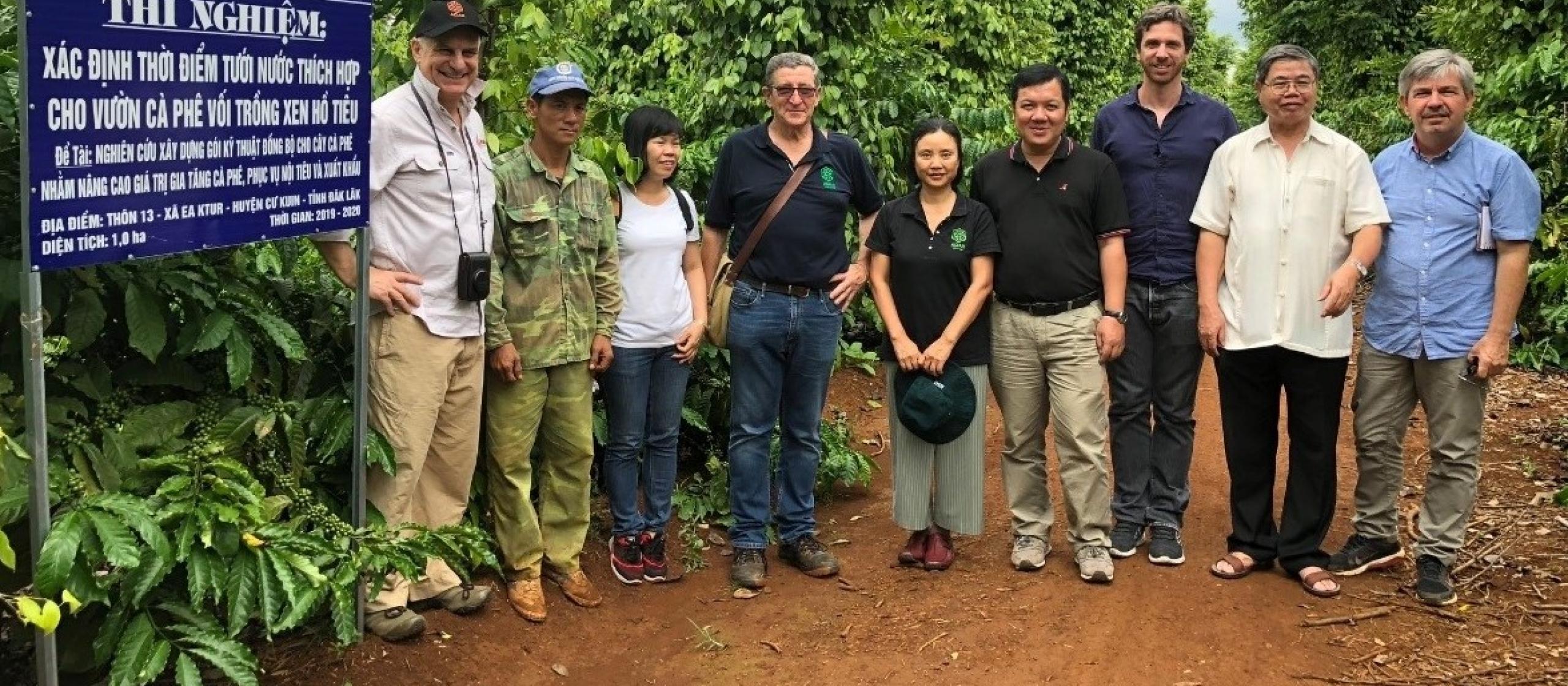 group of people smiling at camera beside sign