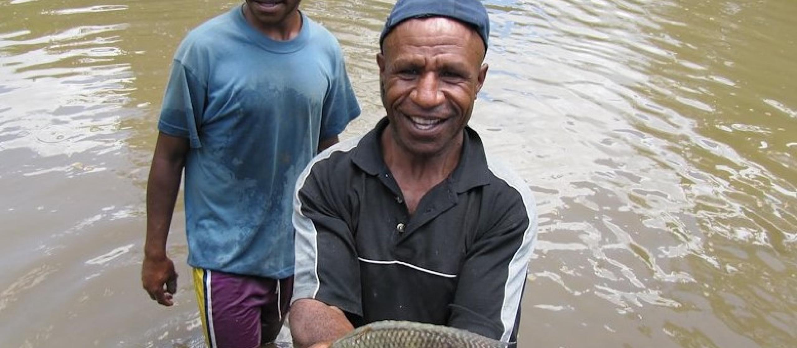 A man holds up a fish