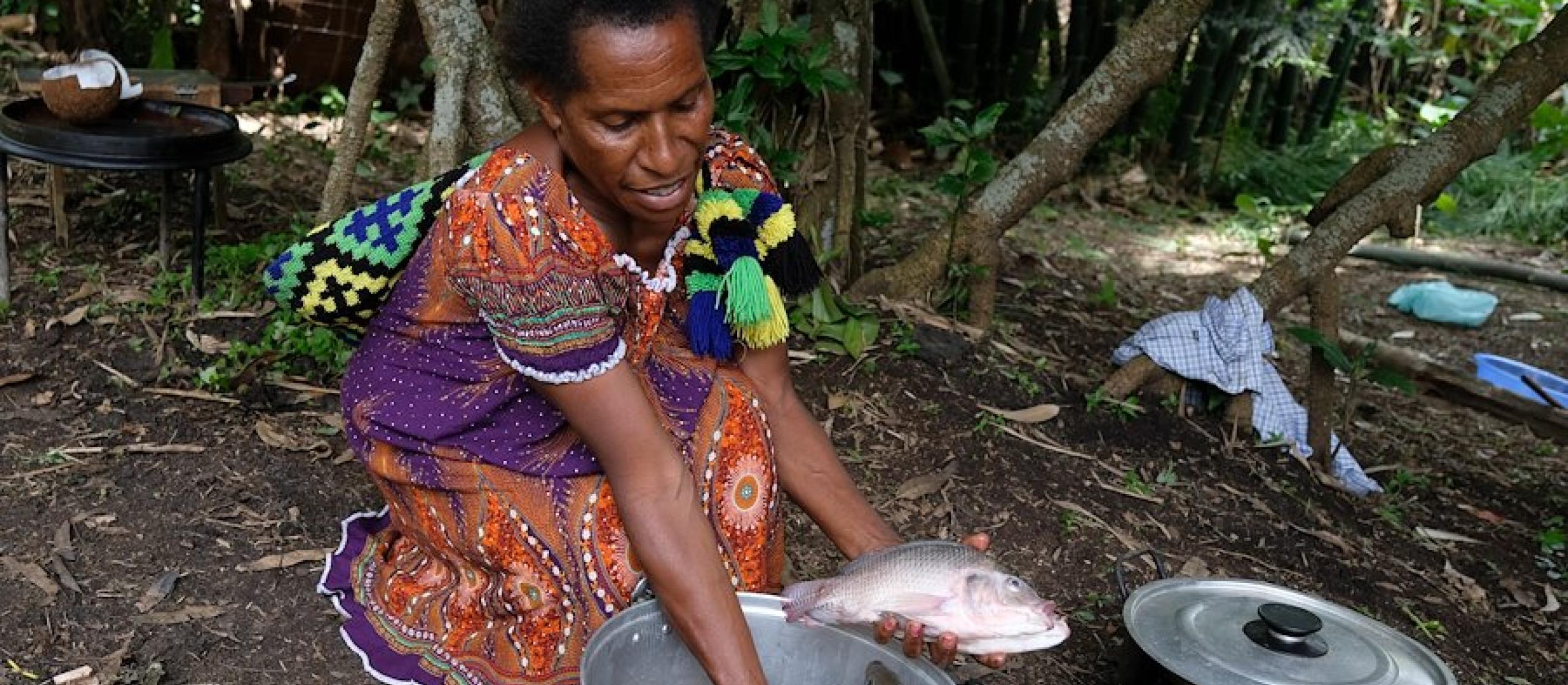 A woman cleans freshly caught fish