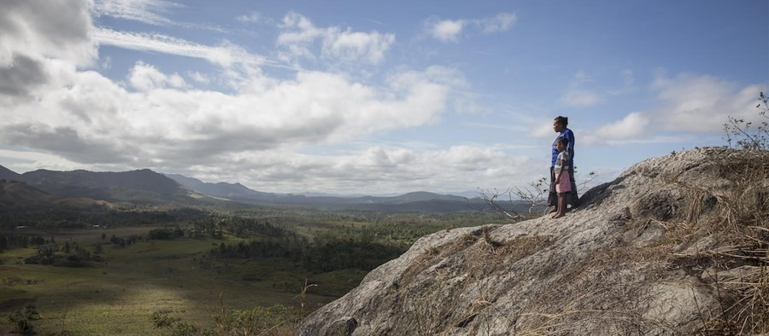 A woman and child look out over a valley