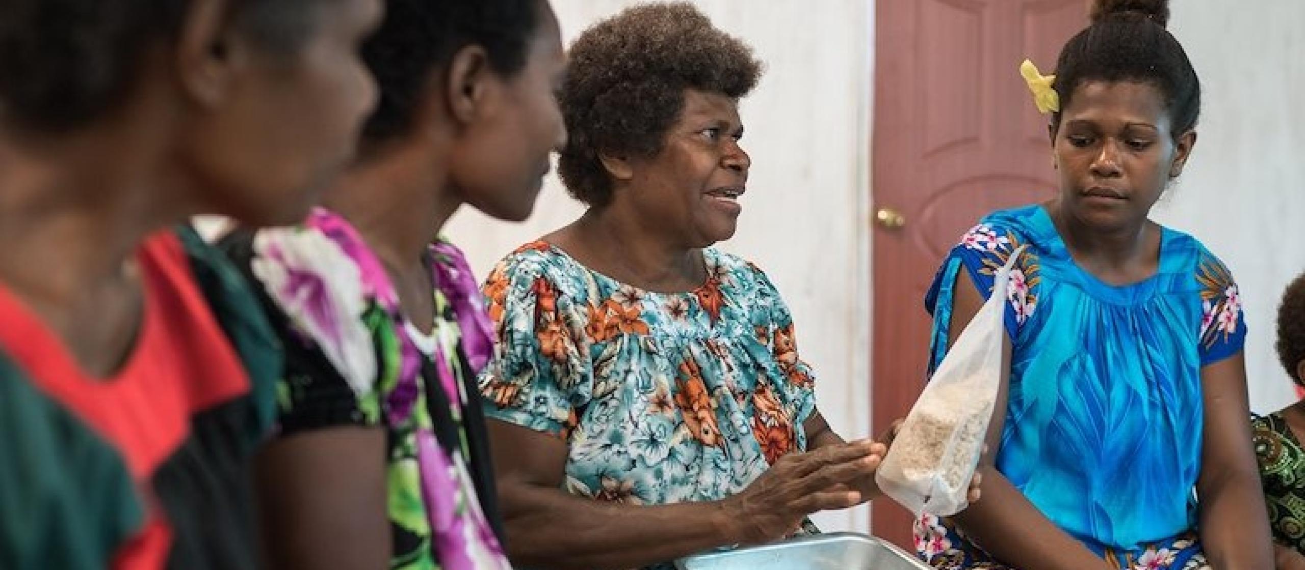 Local women farmers sit in discussion