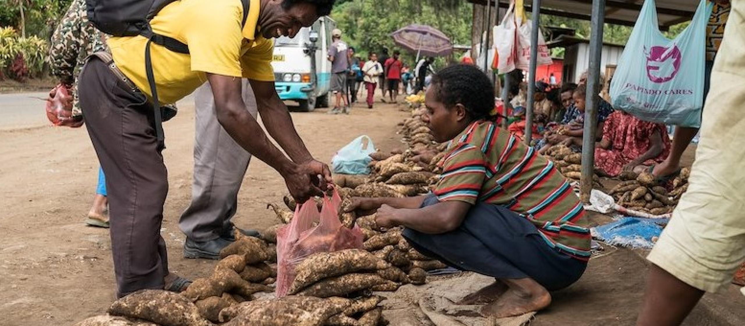 A sweet potato farmers sells her product at the local market`