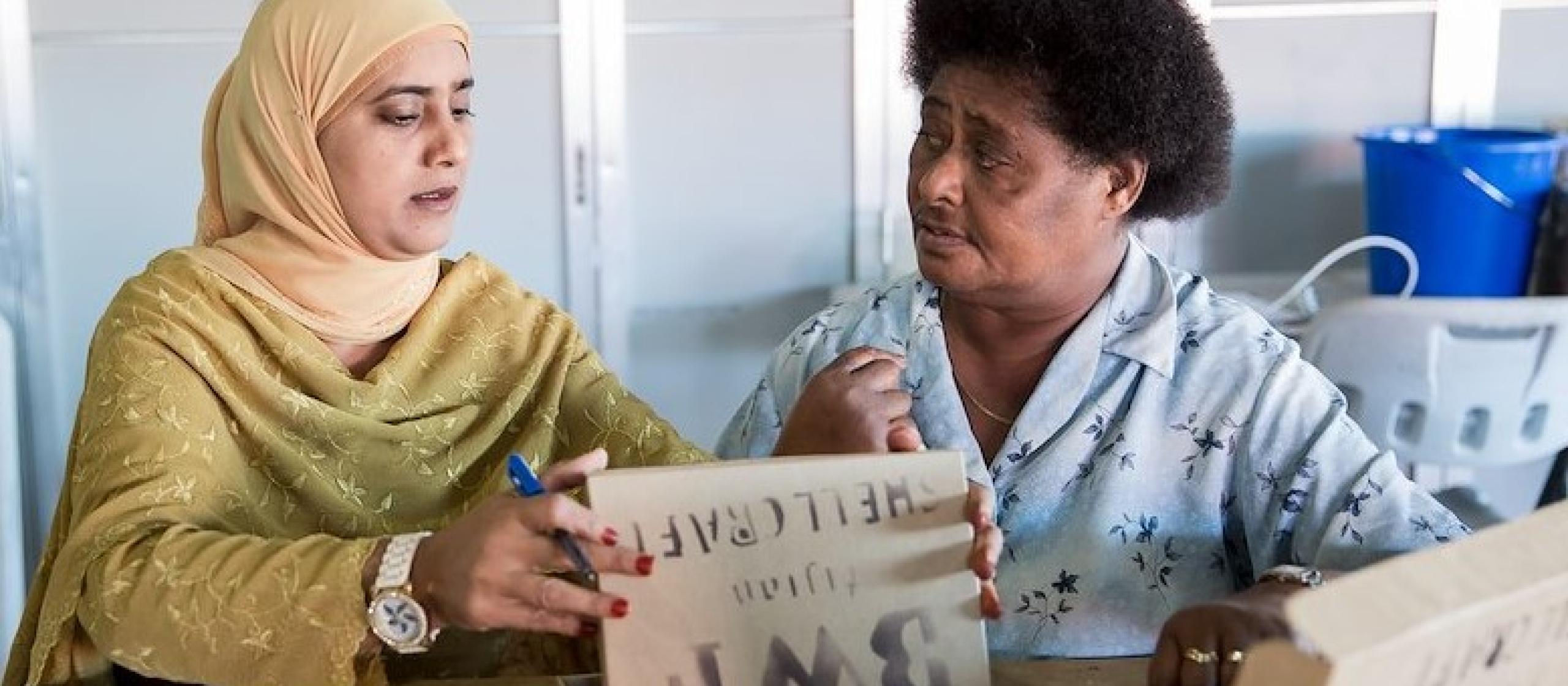 Two women sit in discussion