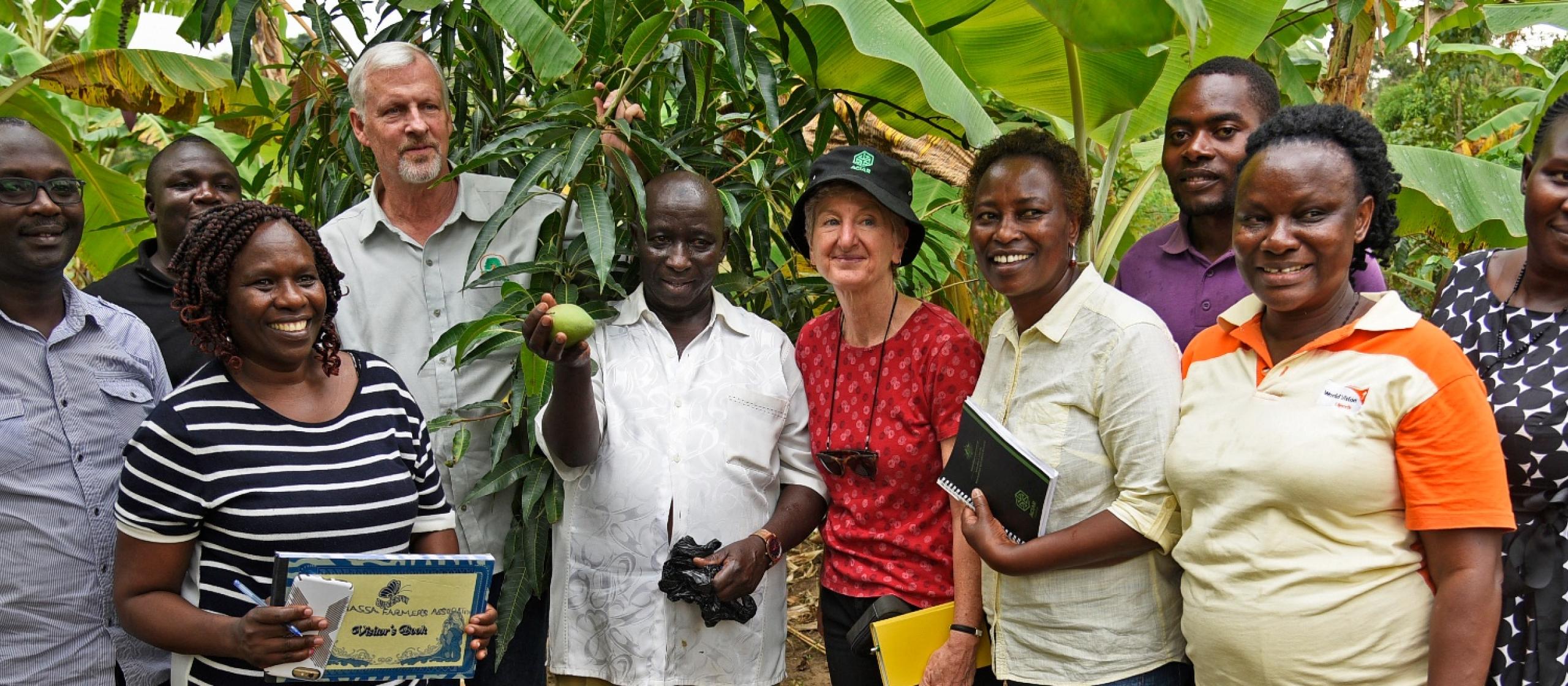 Group of people smiling and standing in front of trees