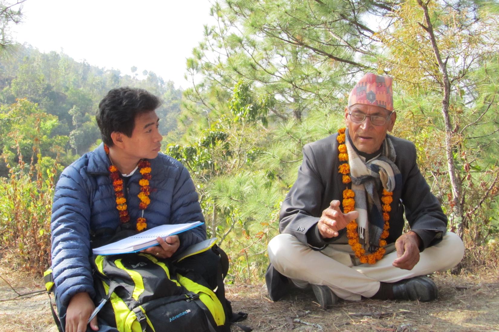 Two men sit in conversation