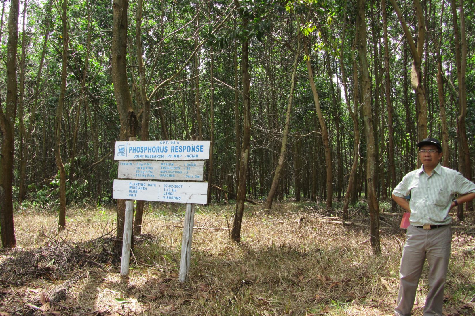 A man stands in front of the fertiliser sign