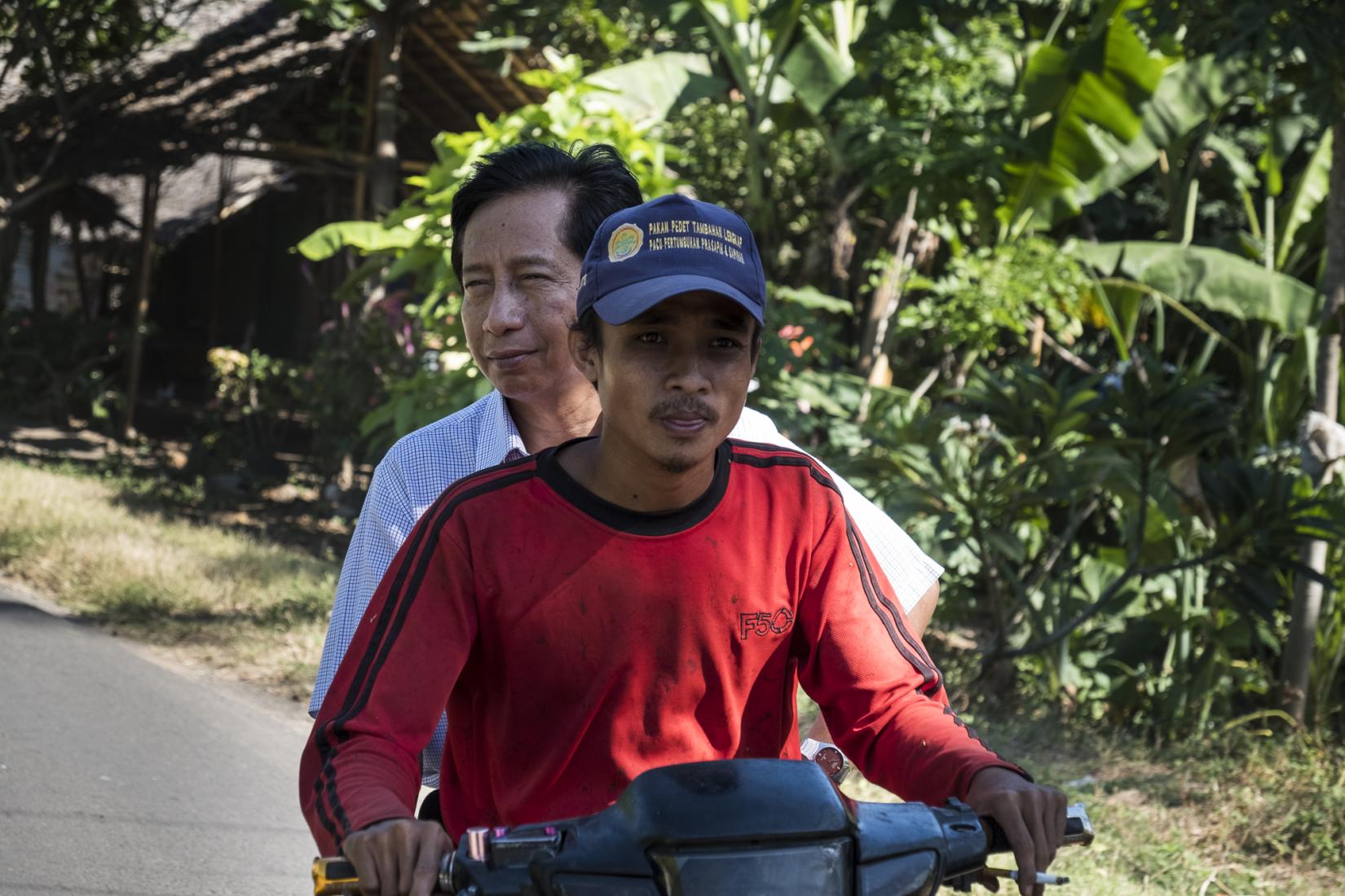 Dr Dahlanuddin one of the Indonesian project leaders rides on the back of a motorbike with a cattle farmer from Karang Kendal hamlet.