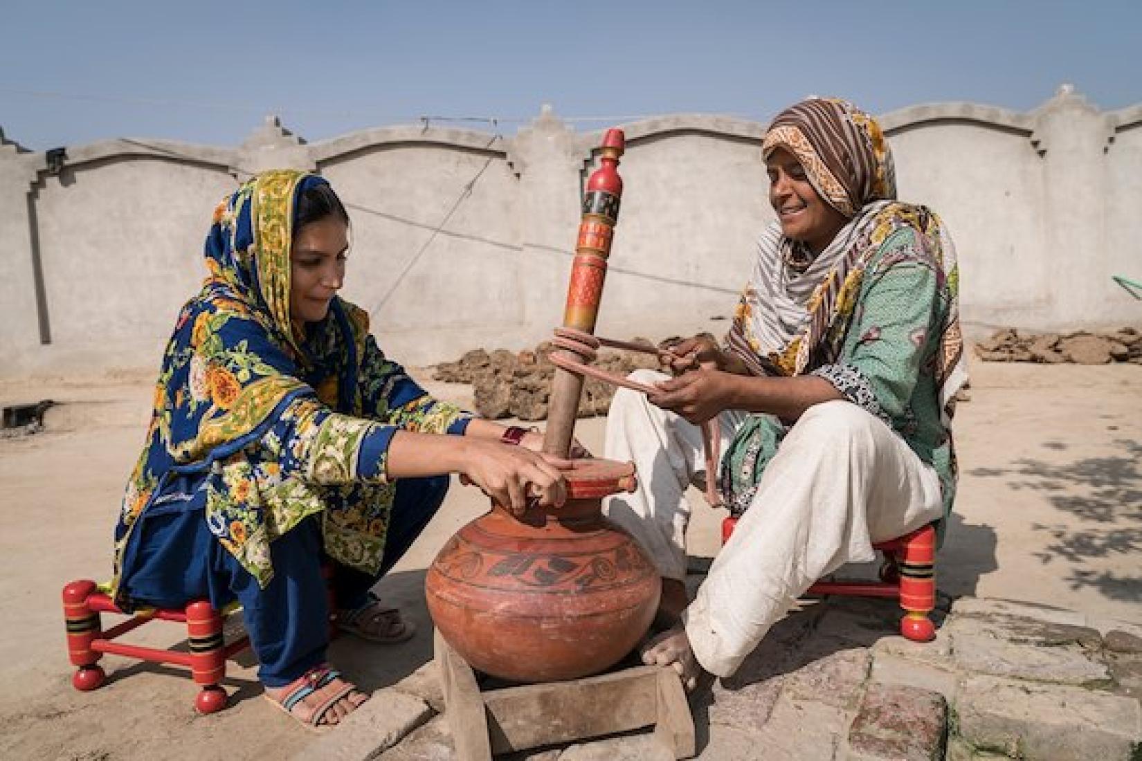 Female dairy farmers churning milk. Image: ACIAR/Conor Ashleigh