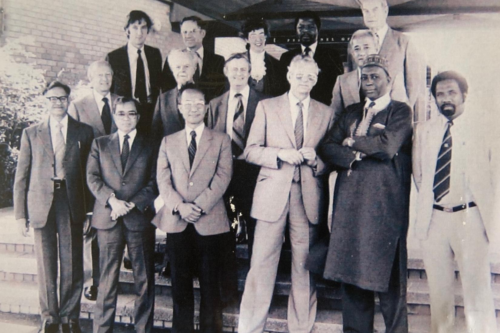 Black and white photo of men standing on steps