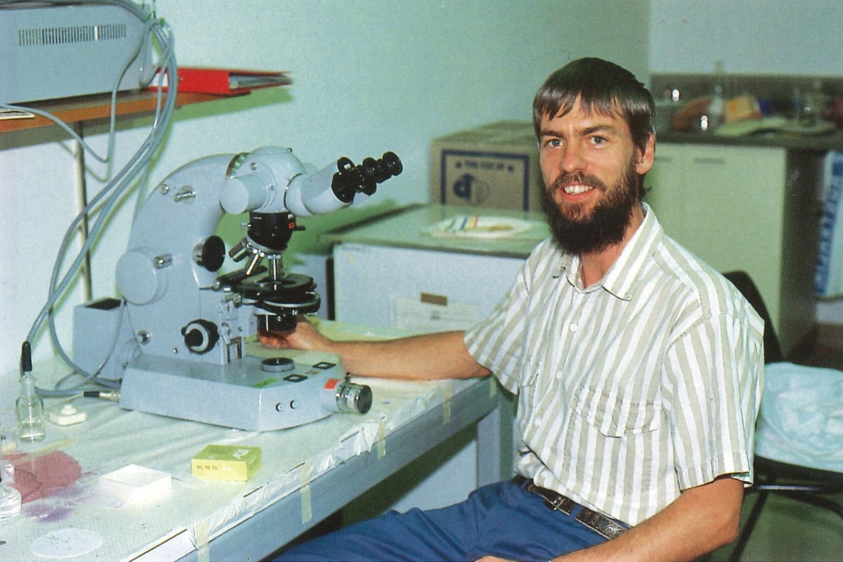 Man sitting in front of microscope