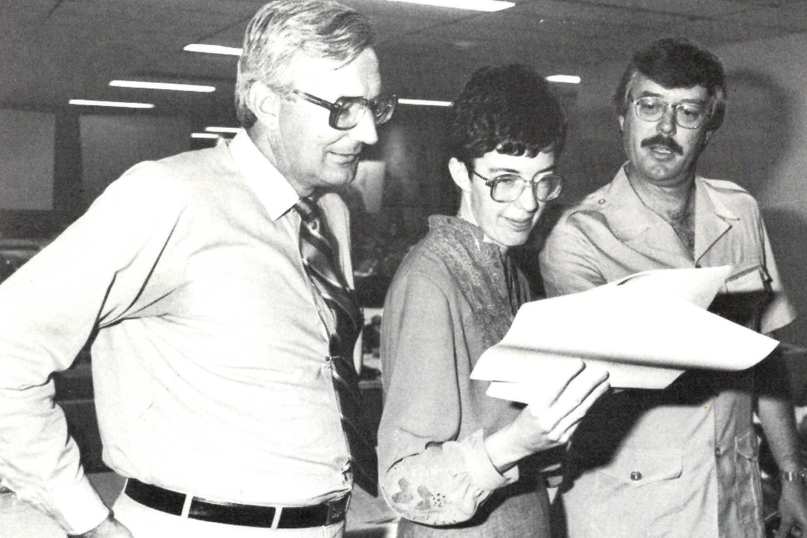 3 people looking at a report