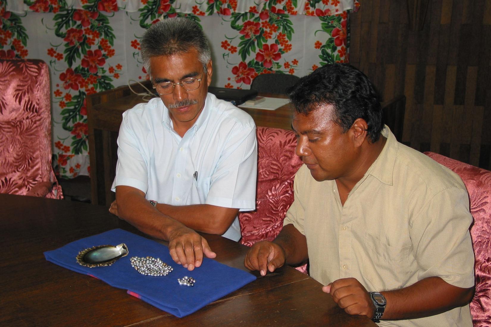 2 men inspecting pearls