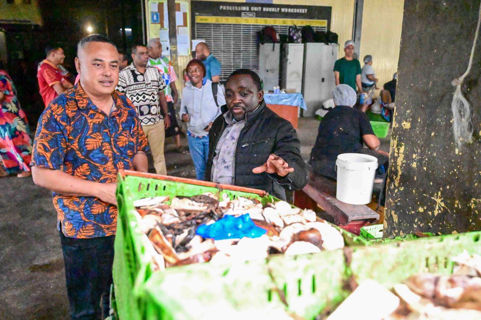 Dr Chrysantus M. Tanga (right) from icipe examines food waste at a processing plant in Fiji. 