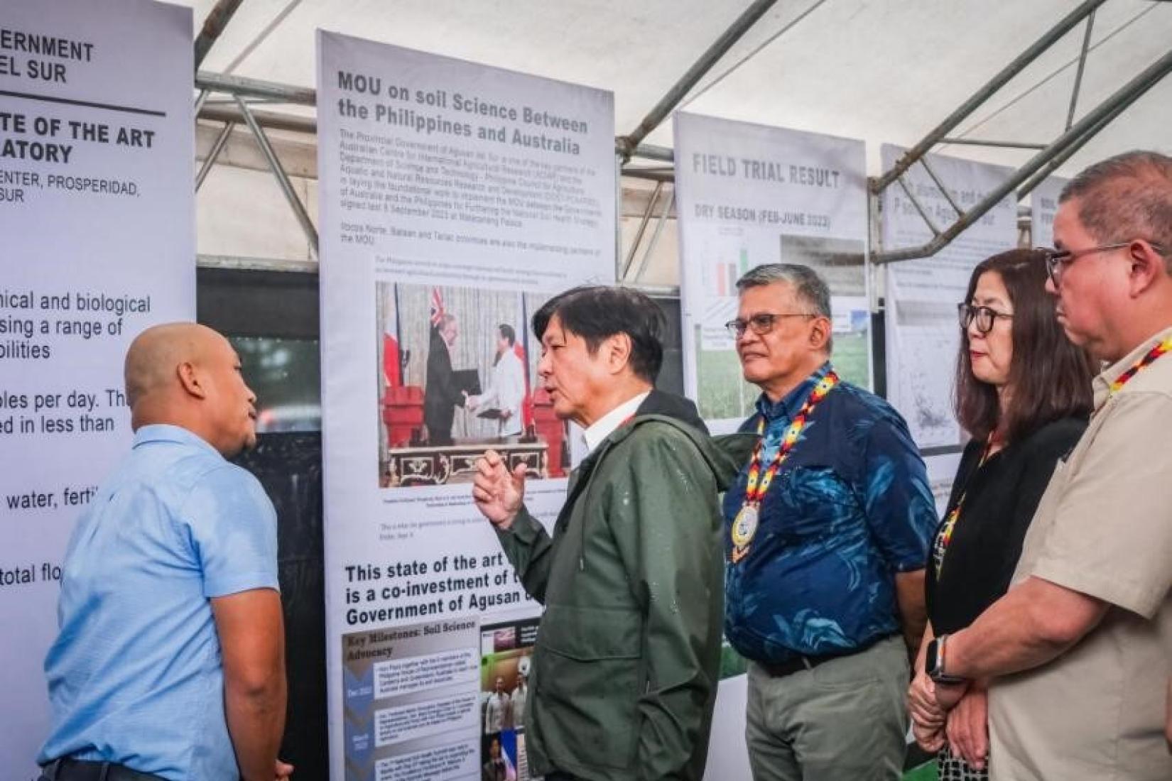 Group of people standing in front of banners in conversation. 