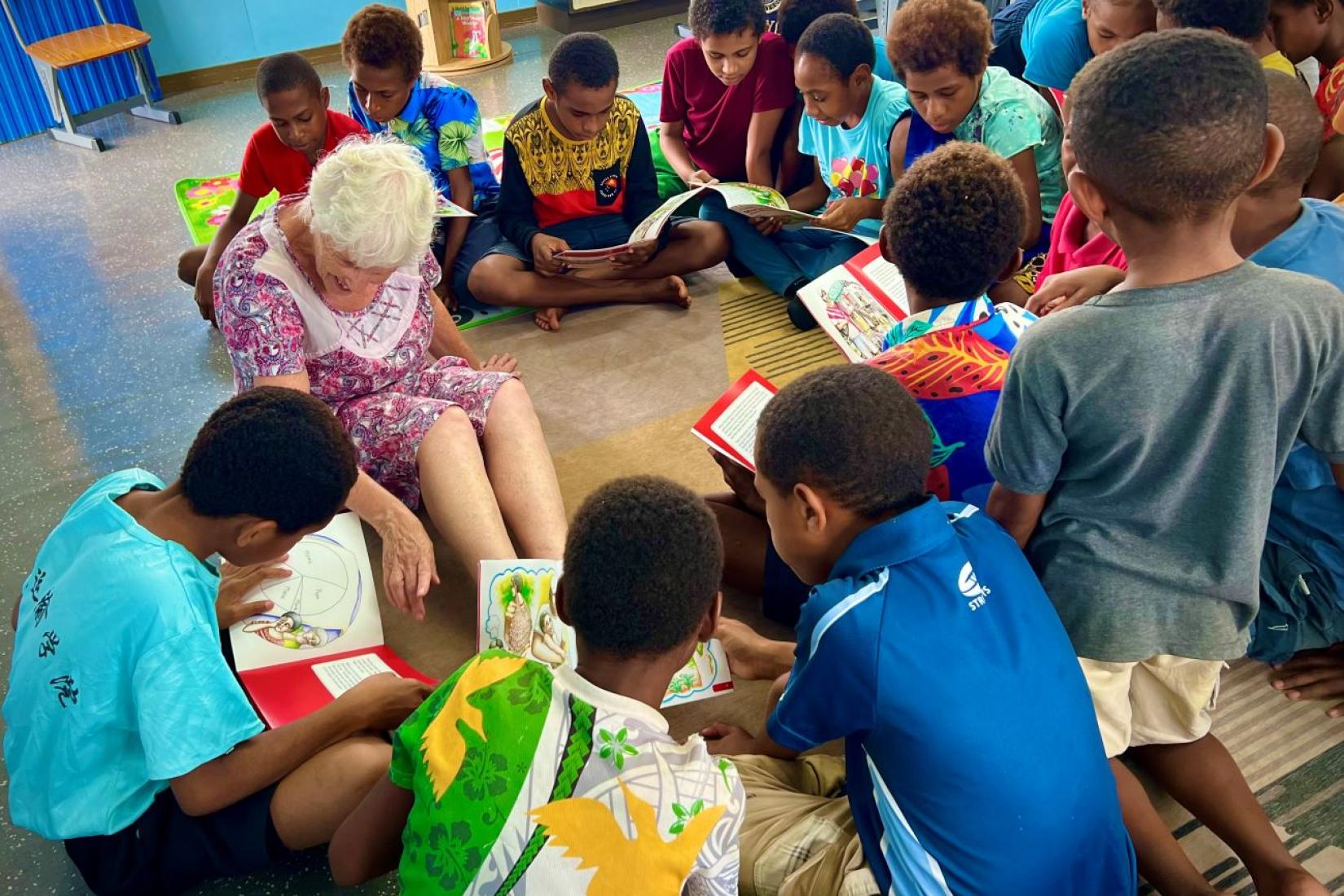 Group of children reading books together in a circle