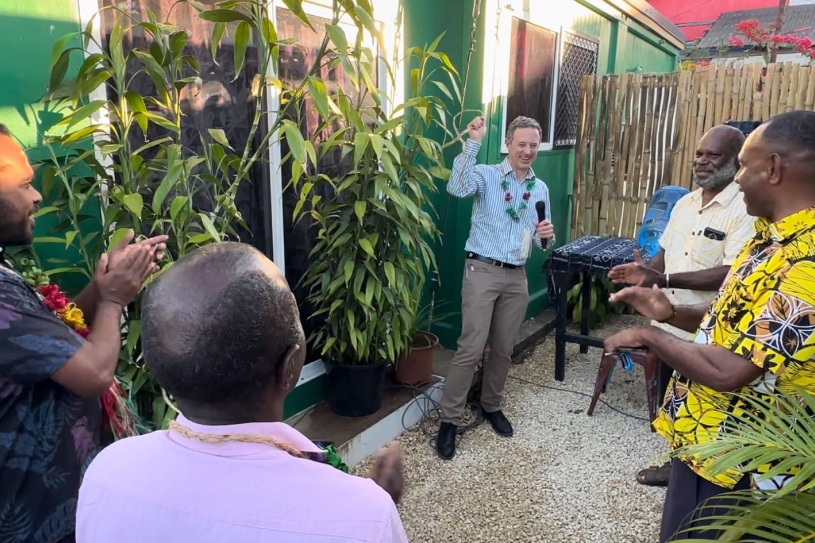Man speaking into a microphone in front of an audience