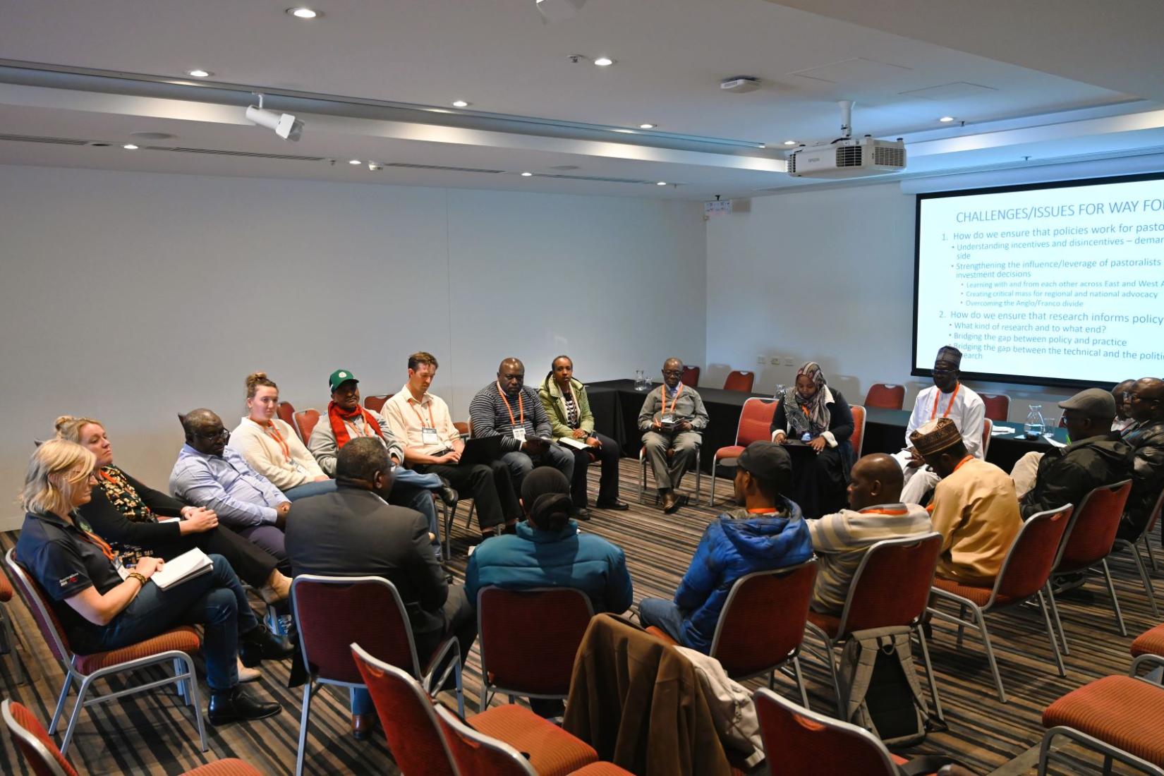 A group of people sitting in a room on chairs in a circle