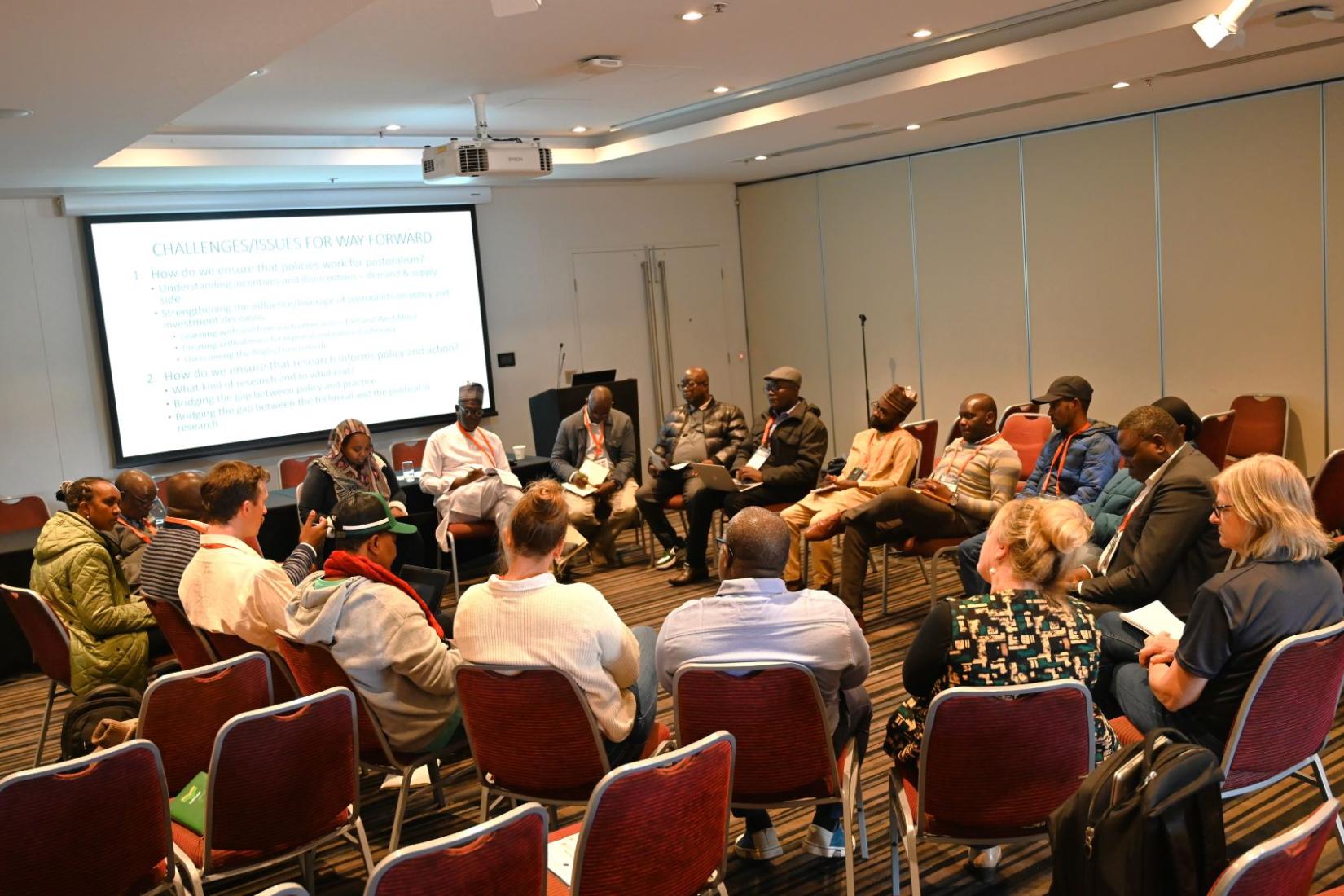 Group of people in a room sitting in a circle on chairs