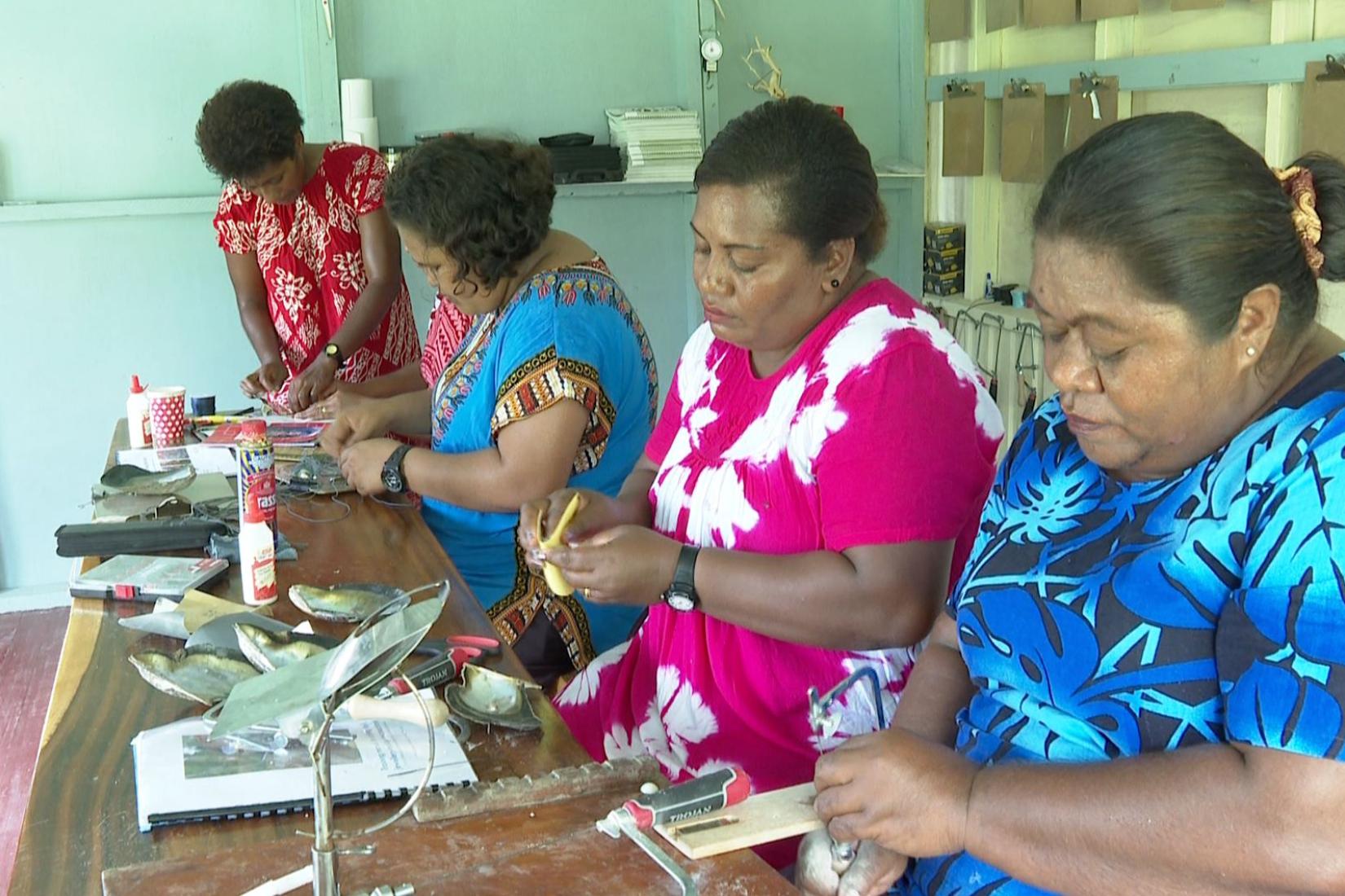 Women at desks working on handicrafts