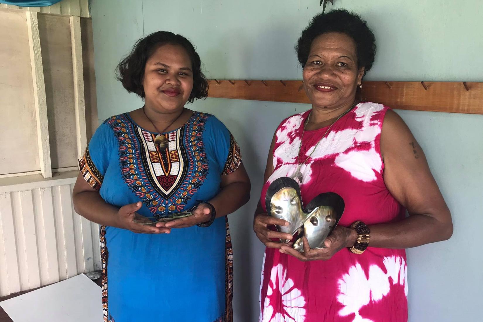 Two women holding oyster shells