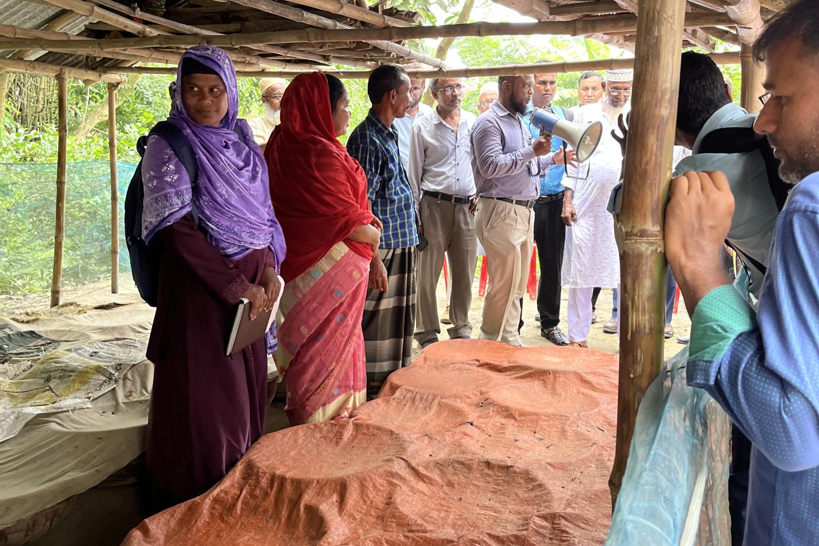Community members standing at a local storage site with sacks of grain