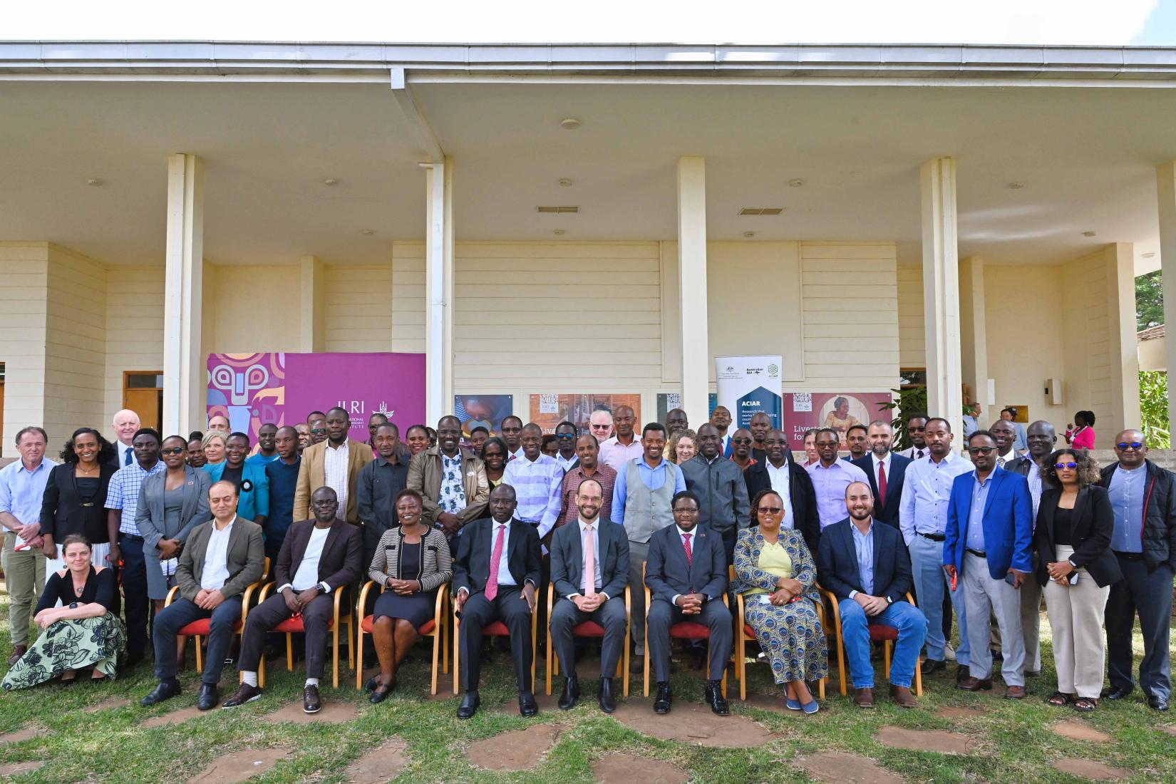 Large group photo outside a building, with participants standing and seated in rows.
