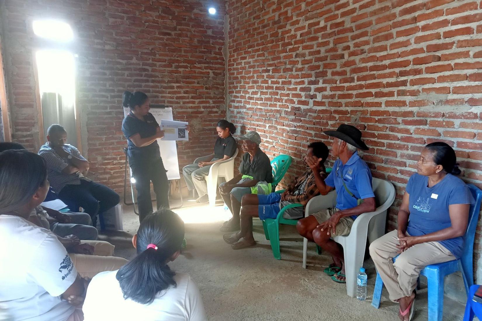 Community meeting held inside a brick building.