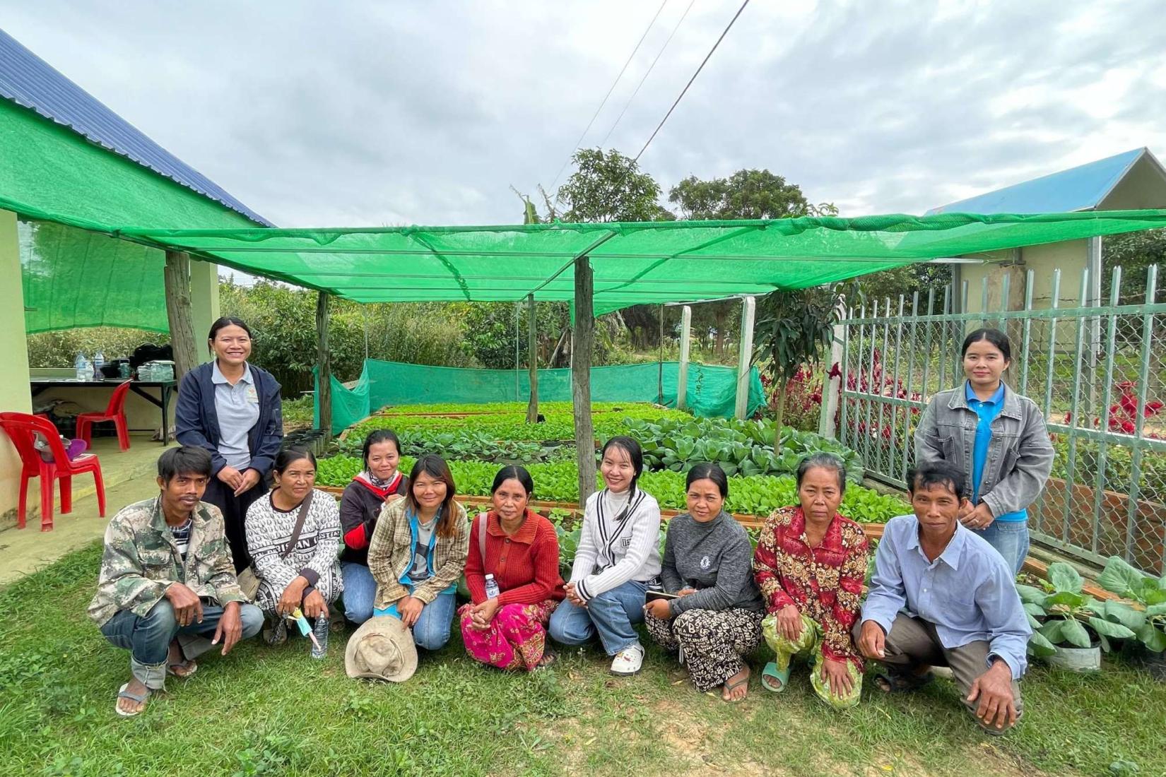 Group photo of people sitting in their home vegetable garden