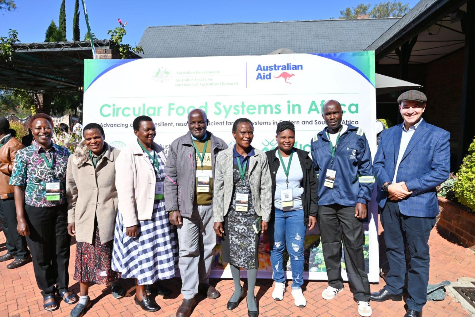 Group of people posing in front of a Circular Food Systems in Africa event banner.