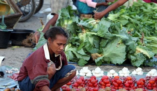 Woman in market selling vegetables