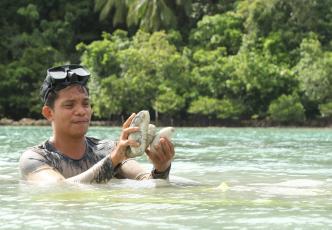Roberto Gonzales Jr, a sandfish ranch co-manager in Buyayawon, Mercedes, Eastern Samar, inspects a sandfish.