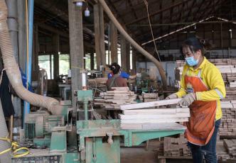 A worker at Burapha cutting wood
