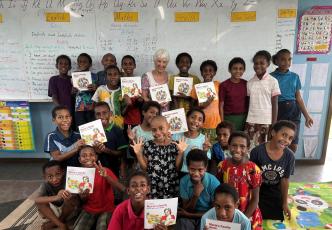 Children in a classroom holding picture books