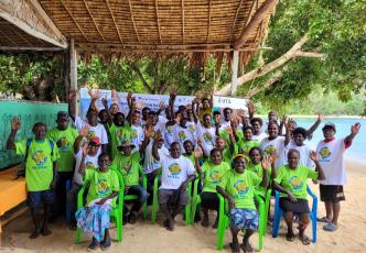 Community group gathered outdoors by the beach during a mangrove conservation workshop