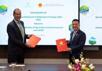 ACIAR and Vietnam Ministry of Agriculture and Environment representatives exchange signed research collaboration documents in Canberra.