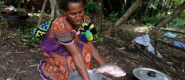 A woman cleans freshly caught fish