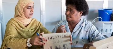 Two women sit in discussion