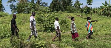 Farmers walk through a field