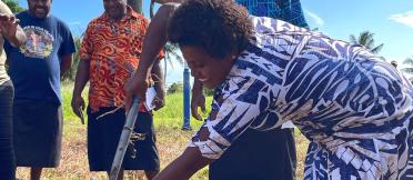 Female farmer shoveling soil into a bucket 