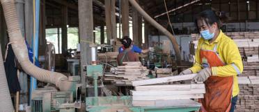 A worker at Burapha cutting wood