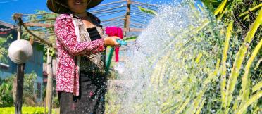 A farmer waters her garden in Ekxang Village, Lao PDR.