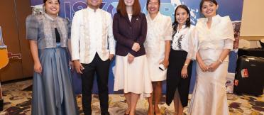 A group of people standing and smiling for a photo. 