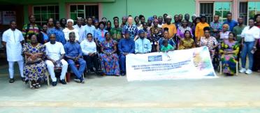 A group of people sitting together behind a project banner