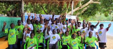 Community group gathered outdoors by the beach during a mangrove conservation workshop